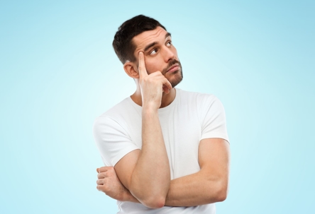 A man thinking about something in front of a blue background