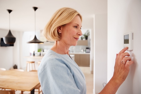 Picture of Woman Adjusting Thermostat