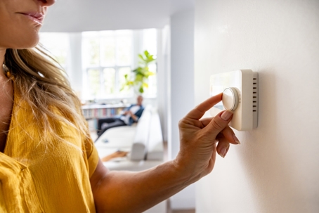 woman using thermostat